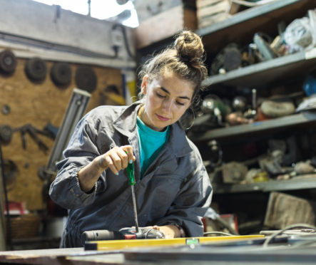 young woman fixing tool at work
