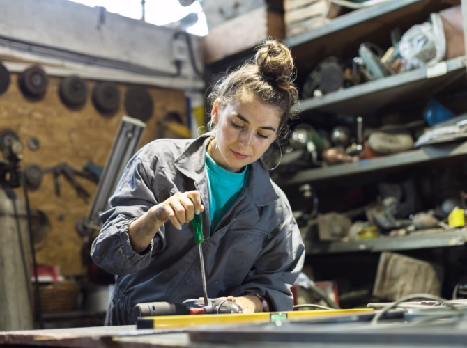 young woman fixing tool at work